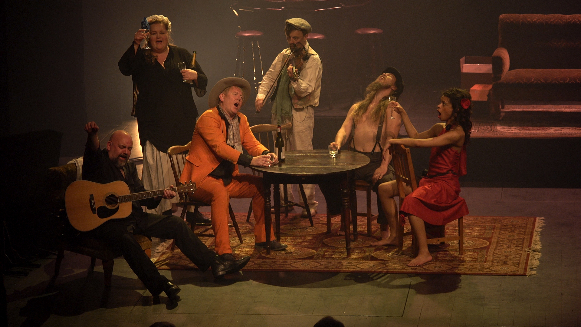 Ensemblet samlet rundt bordet i en scene